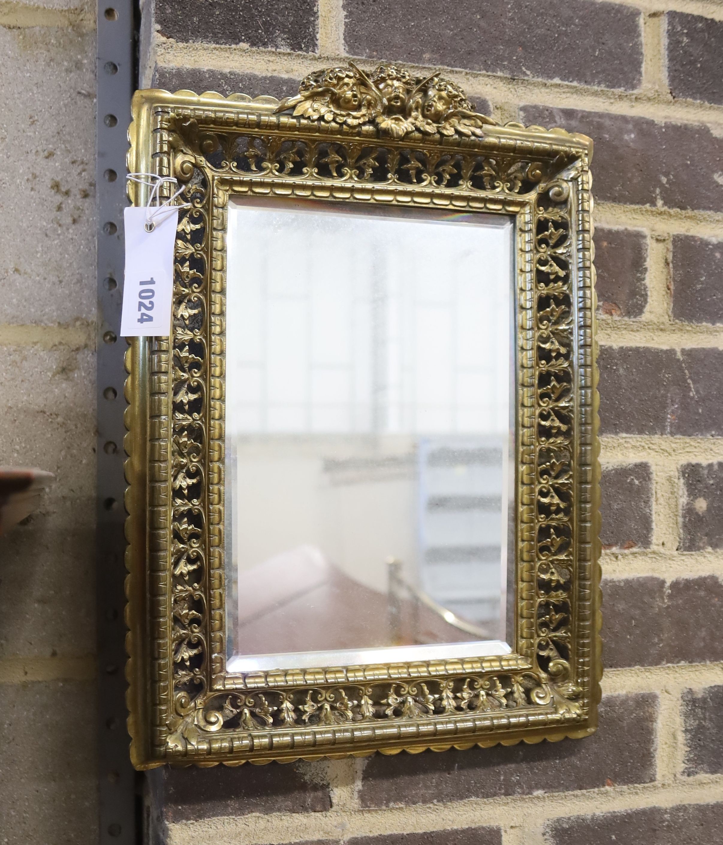 An early 20th century rectangular pierced brass wall mirror with cherub pediment, width 29cm, height 40cm
